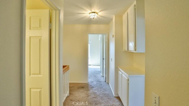 corridor featuring light colored carpet