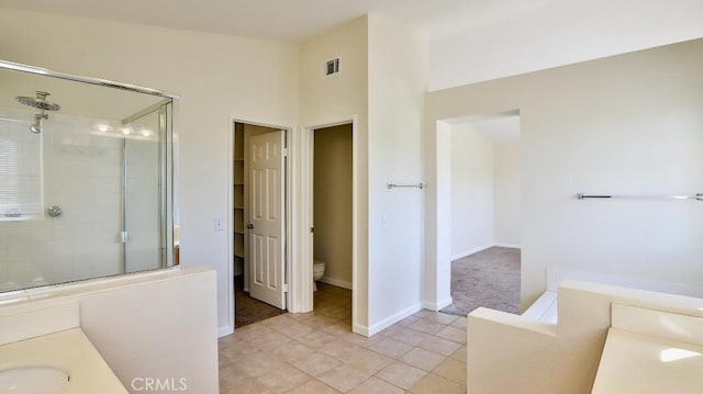 bathroom with vanity, tile patterned flooring, toilet, and walk in shower