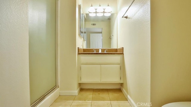 bathroom with tile patterned floors, a shower with shower door, and vanity