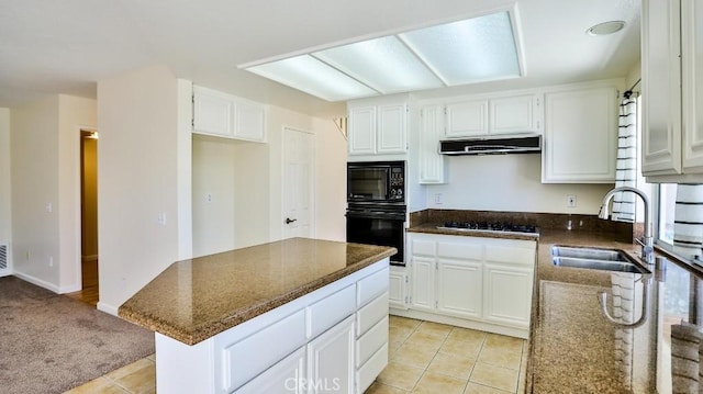 kitchen with sink, dark stone countertops, black appliances, and white cabinetry