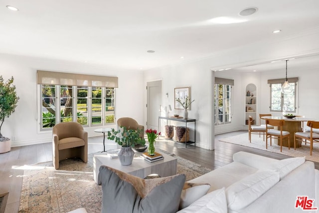 living room with plenty of natural light, light hardwood / wood-style flooring, and crown molding