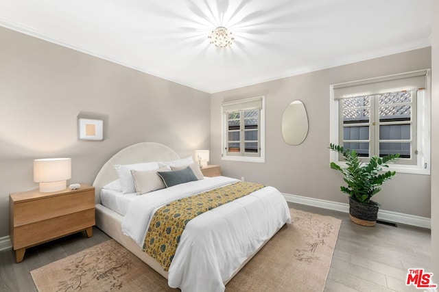 bedroom featuring ornamental molding and hardwood / wood-style floors