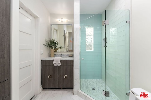 bathroom with a shower with shower door and vanity