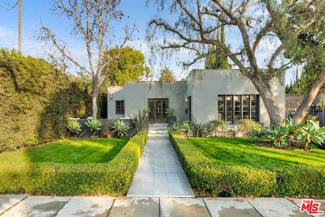 view of front of house featuring a front yard and french doors