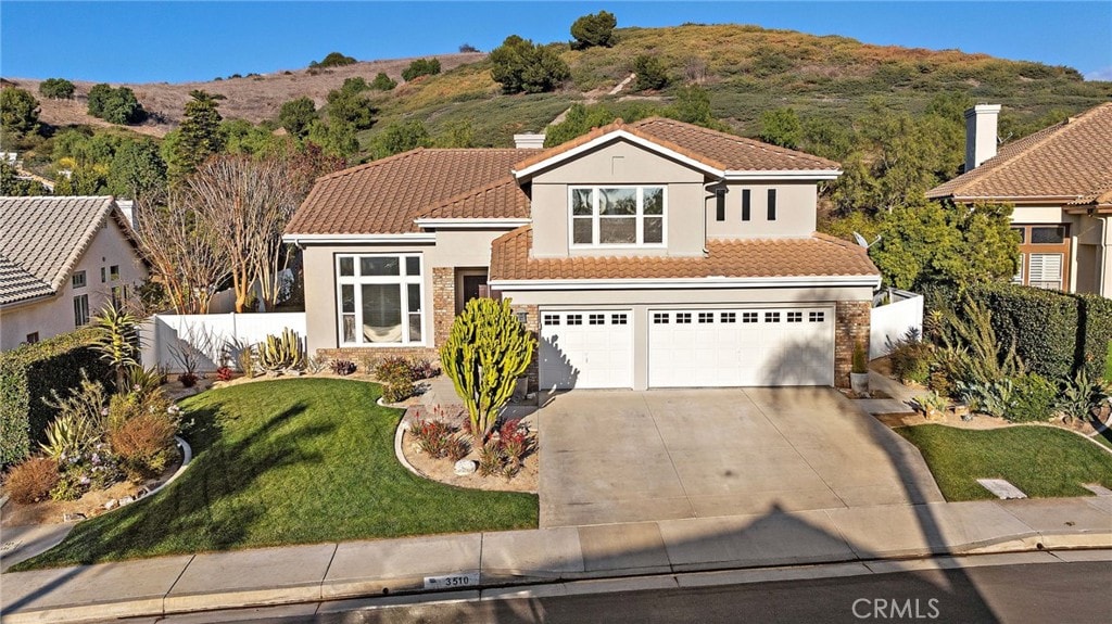 mediterranean / spanish-style home with a front lawn and a garage