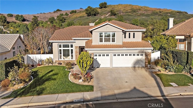 mediterranean / spanish-style home with a front lawn and a garage