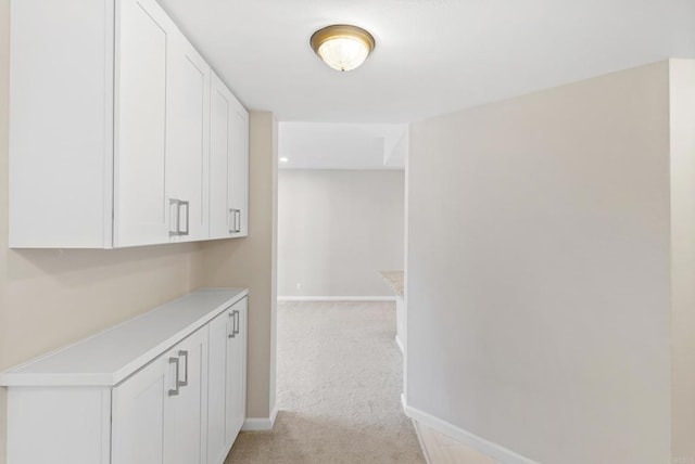 hallway with light colored carpet