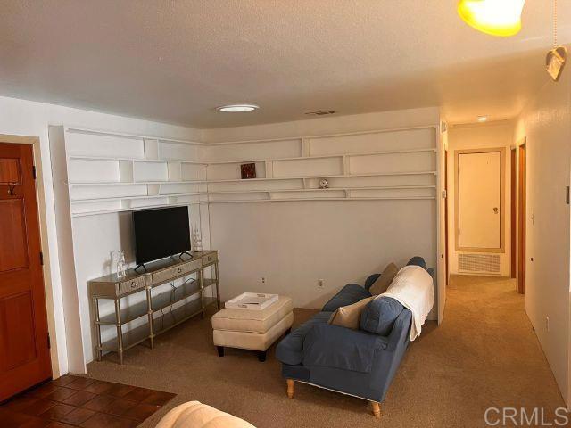 living room with dark carpet and a textured ceiling