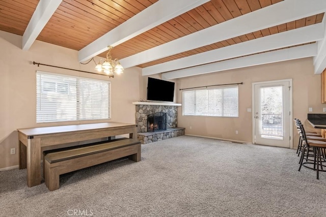 carpeted living room featuring an inviting chandelier, beam ceiling, wood ceiling, and a fireplace