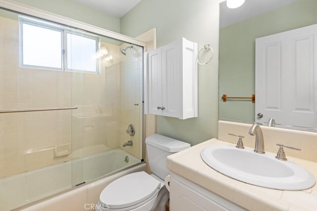 full bathroom featuring toilet, bath / shower combo with glass door, and vanity