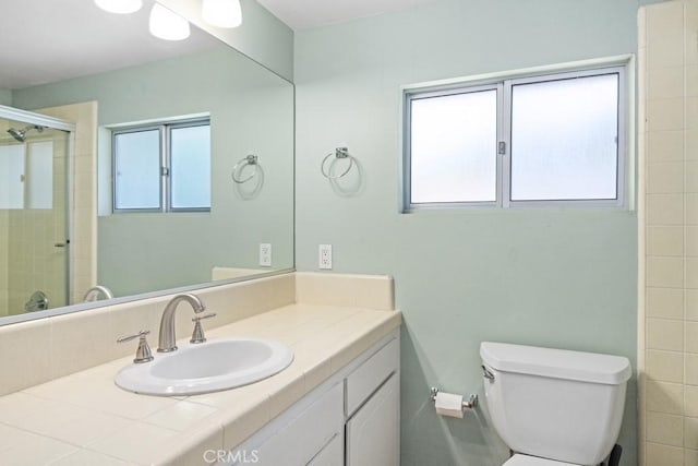 bathroom with toilet, vanity, and an enclosed shower