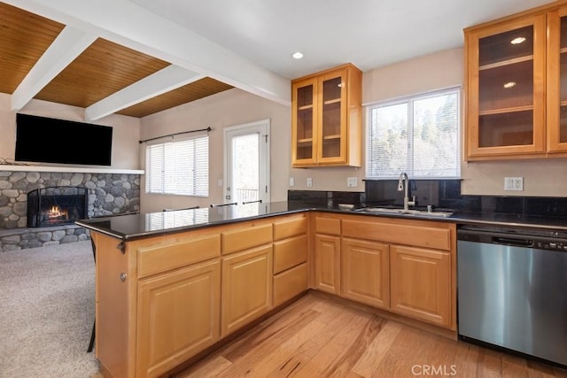 kitchen featuring kitchen peninsula, a fireplace, dishwasher, beam ceiling, and sink