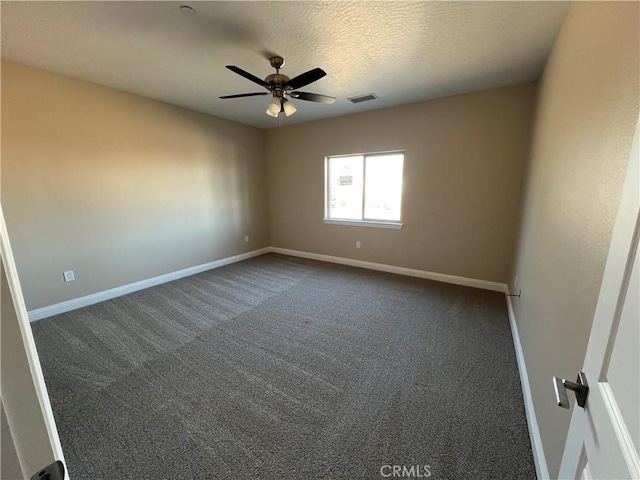 spare room featuring a textured ceiling, ceiling fan, and dark carpet