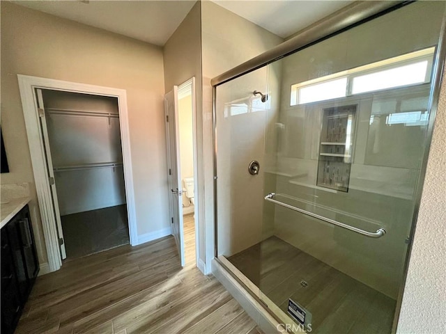 bathroom featuring vanity, toilet, hardwood / wood-style flooring, and walk in shower