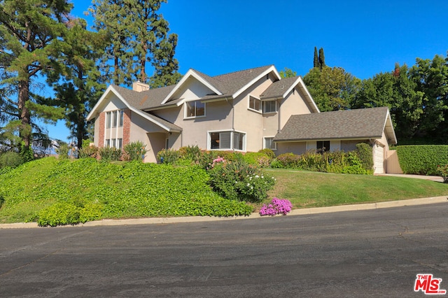 view of front of property with a front yard and a garage