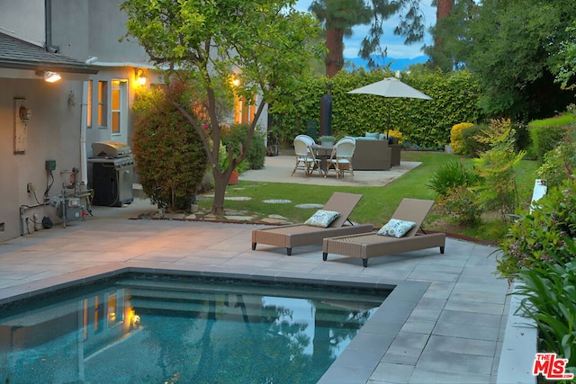 view of swimming pool featuring a patio area, outdoor lounge area, a grill, and a yard