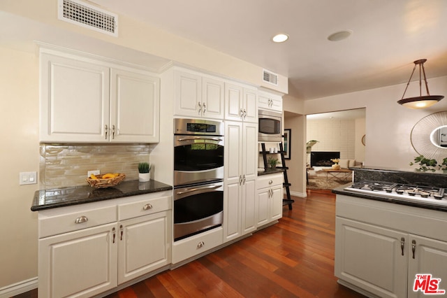 kitchen featuring hanging light fixtures, white cabinets, dark hardwood / wood-style floors, and stainless steel appliances