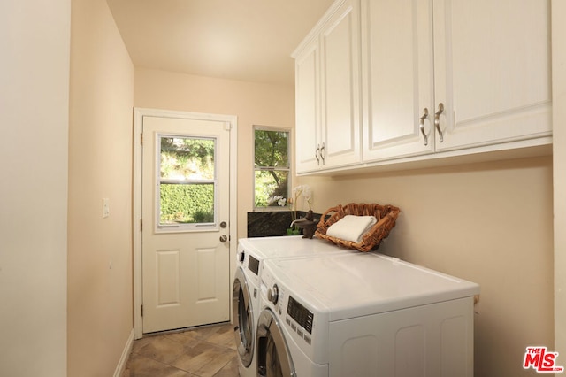 laundry area featuring washing machine and clothes dryer and cabinets