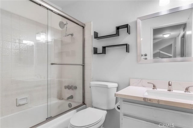 full bathroom featuring shower / bath combination with glass door, vanity, and toilet