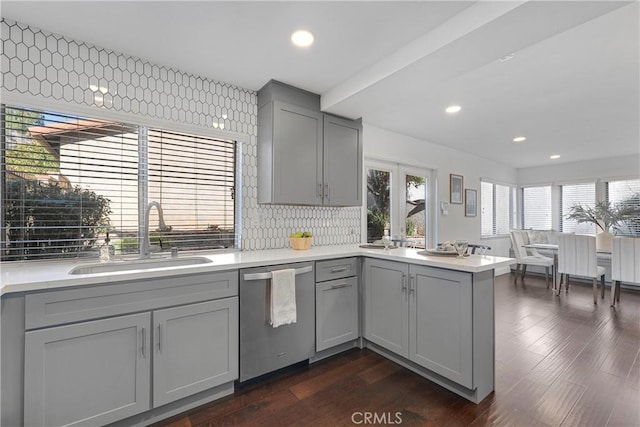 kitchen with gray cabinetry, dishwasher, tasteful backsplash, and sink