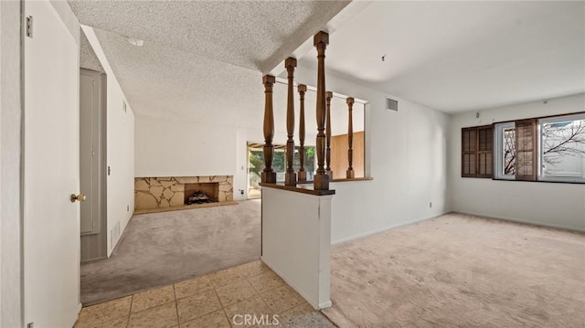 corridor with light colored carpet and a textured ceiling