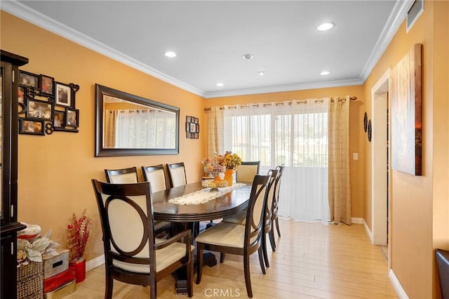 dining area featuring crown molding and light hardwood / wood-style flooring