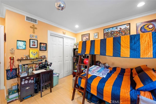 bedroom featuring a closet, crown molding, and hardwood / wood-style flooring