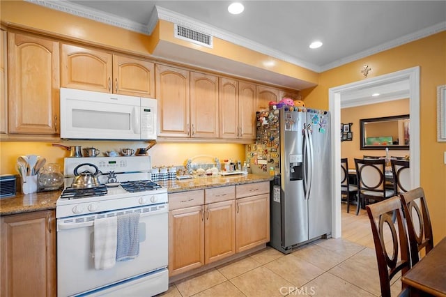 kitchen with light tile patterned flooring, light stone counters, and white appliances