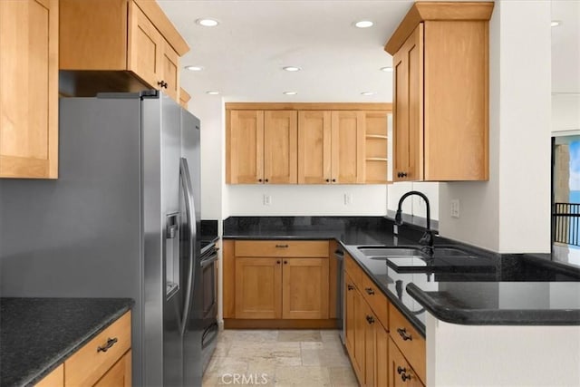 kitchen with stainless steel appliances, sink, and dark stone counters