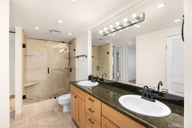 bathroom with vanity, a shower with shower door, and toilet