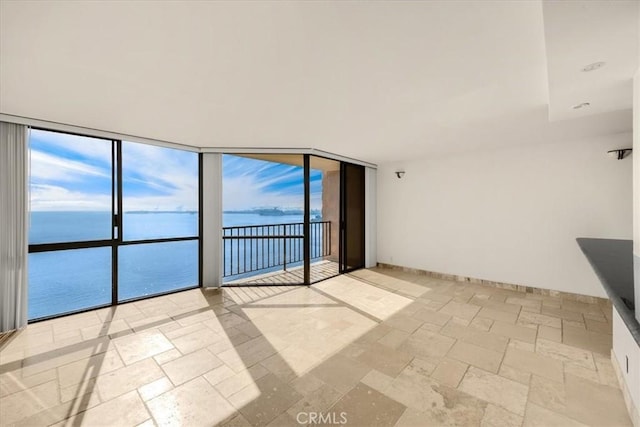 empty room featuring a wall of windows and a water view