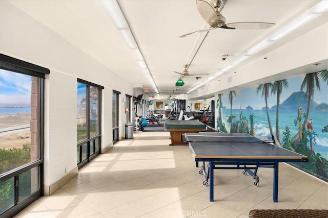 recreation room with a water view and ceiling fan