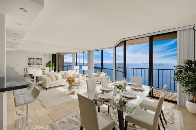 dining room featuring floor to ceiling windows and a water view