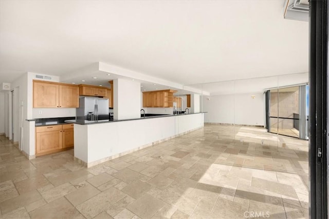 kitchen with sink, stainless steel fridge with ice dispenser, and a kitchen island