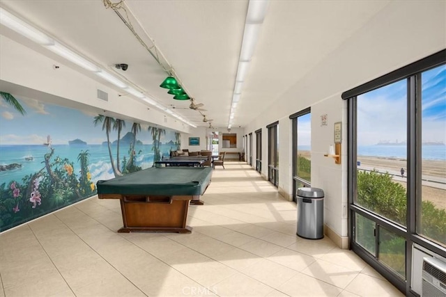 game room featuring a water view, pool table, rail lighting, and light tile patterned floors