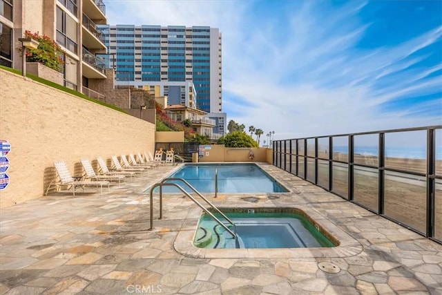 view of pool with a hot tub and a patio