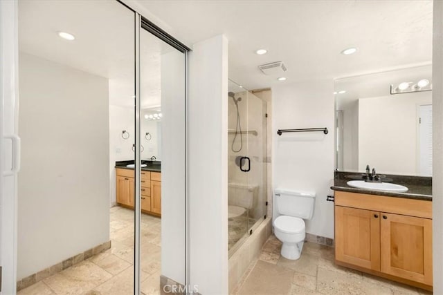 bathroom featuring an enclosed shower, vanity, and toilet