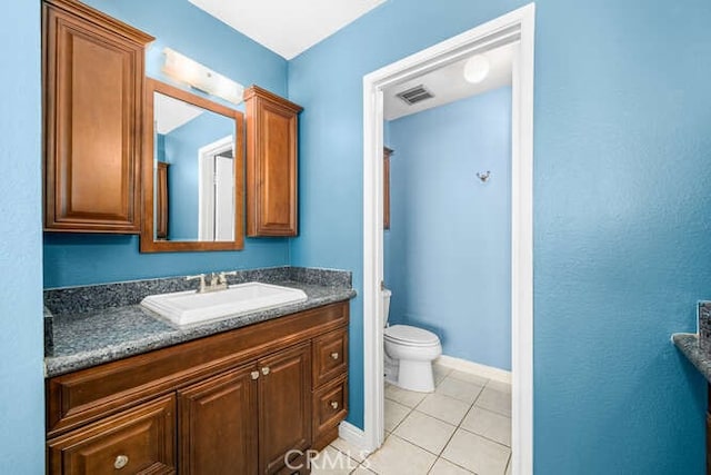 bathroom featuring toilet, vanity, and tile patterned flooring