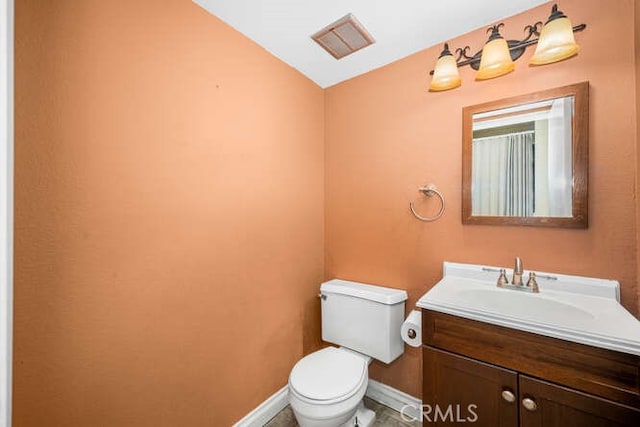 bathroom with toilet, vanity, and lofted ceiling