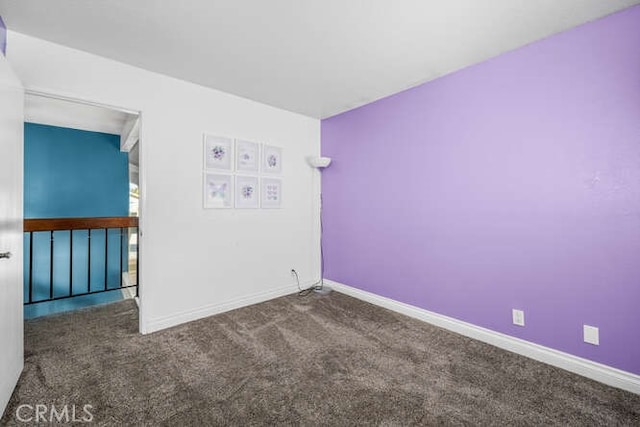 unfurnished room with dark carpet