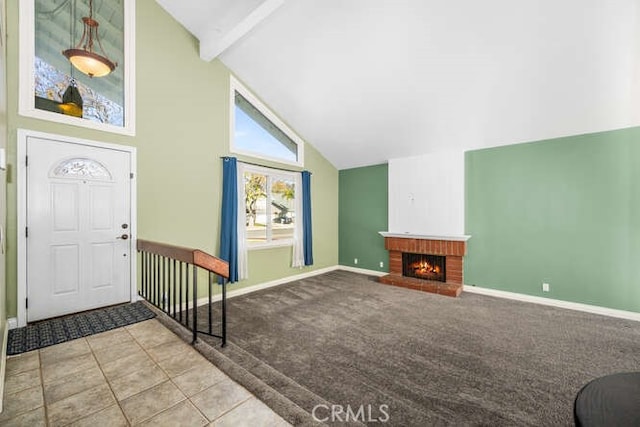 entryway featuring high vaulted ceiling, light carpet, beamed ceiling, and a fireplace