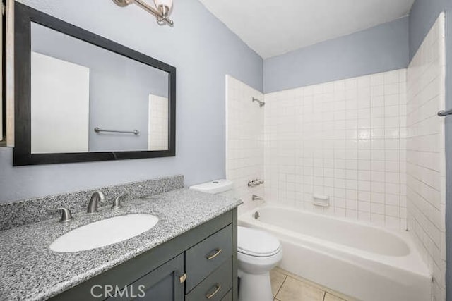 full bathroom with toilet, tiled shower / bath combo, tile patterned floors, and vanity