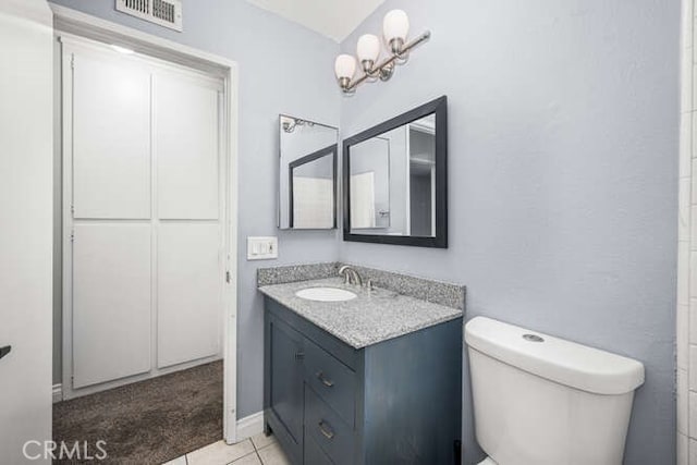 bathroom featuring toilet, tile patterned flooring, and vanity