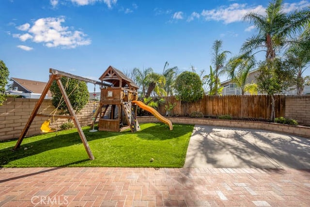 view of playground with a lawn and a patio