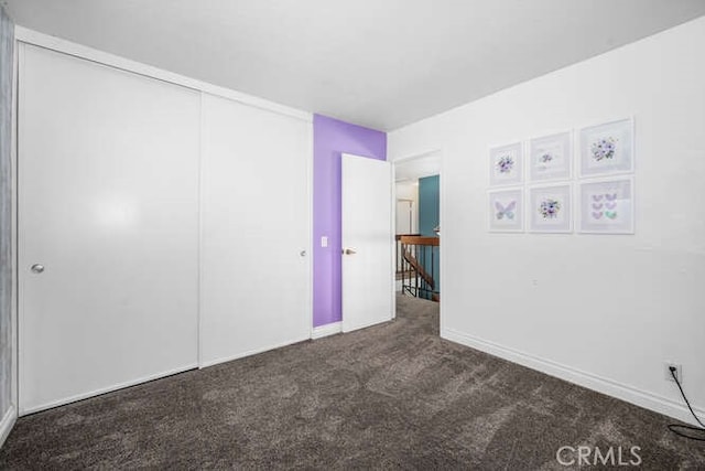 unfurnished room featuring dark colored carpet