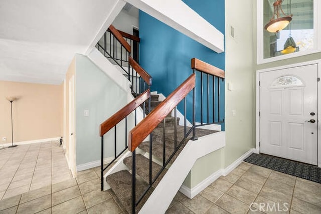 tiled foyer entrance featuring high vaulted ceiling