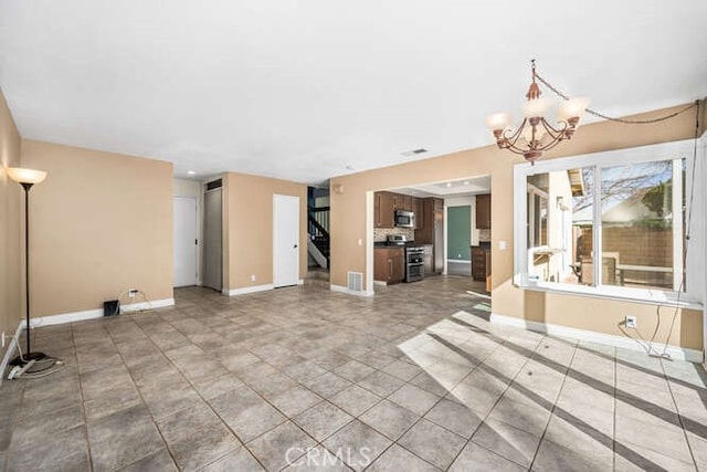 unfurnished living room with a notable chandelier