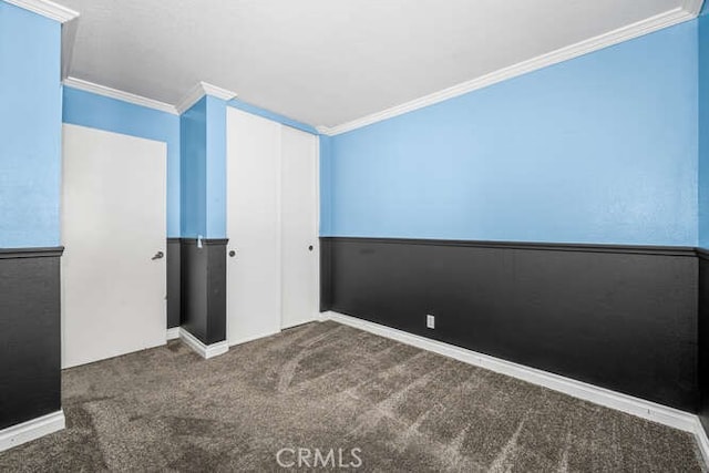 carpeted spare room featuring crown molding