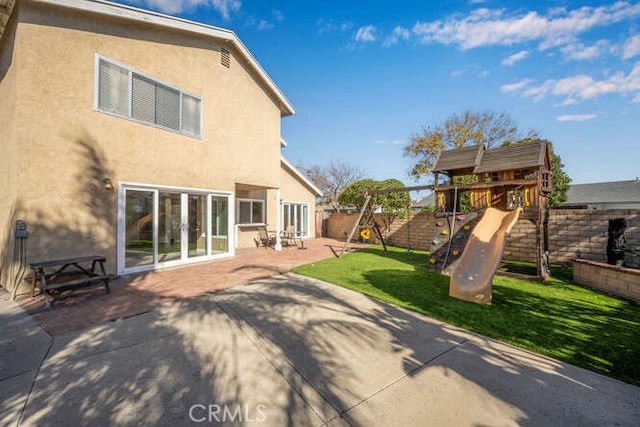 back of property with a playground, a lawn, french doors, and a patio