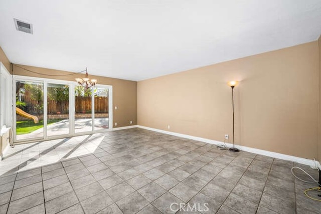 empty room with an inviting chandelier and tile patterned floors